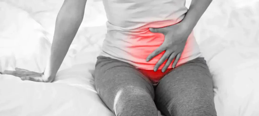 Woman putting her hand on top of her pelvic region.